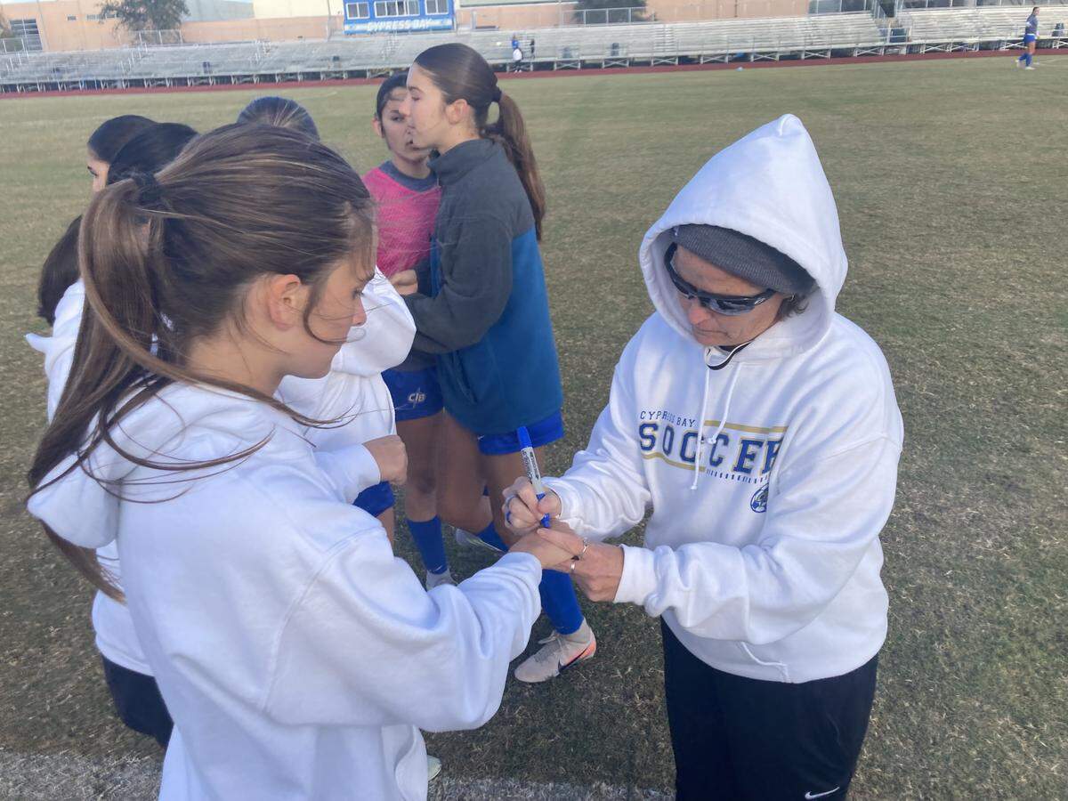 Cypress Bay girls soccer head coach Kate Dwyer (right) has made an annual tradition of writing the number of games her team will need to win to capture a state title on the back of her players hands before the game. She did that again before Thursday’s Region 4-7A quarterfinal contest vs. Goleman at Cypress Bay High.