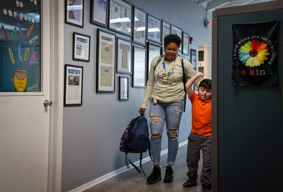 A student arrives as he is escorted to class. The Miami Herald was given tour of the school as it tries to continue to serve the needs of children with autistic students on Monday, September 23, 2025. 