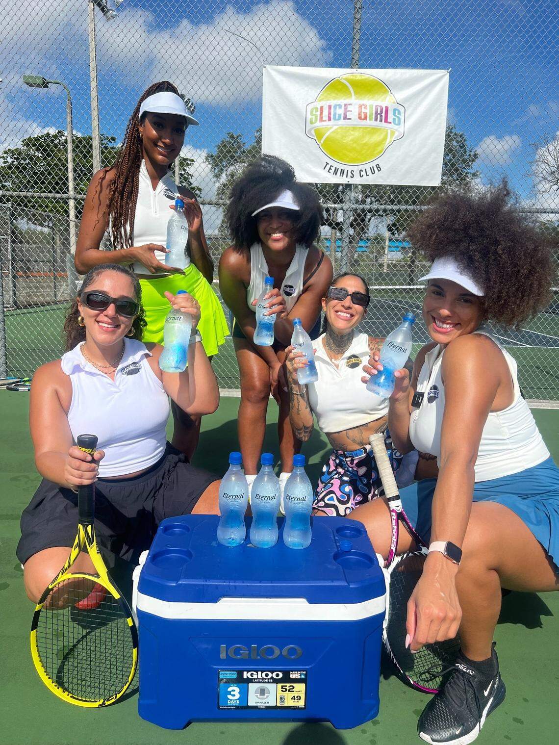 Slice Girls Tennis Club co-founders Carole Hollant (left), Alexandra Philius (second from left), Shaina Jean Louis (middle) and Francesca Morgan (right) pose with participant Starr Hawkins (second from right) during a lesson. Founded by four Miami natives in 2022, the club creates a space for women of color to be themselves while learning a skill historically reserved for the white elite.