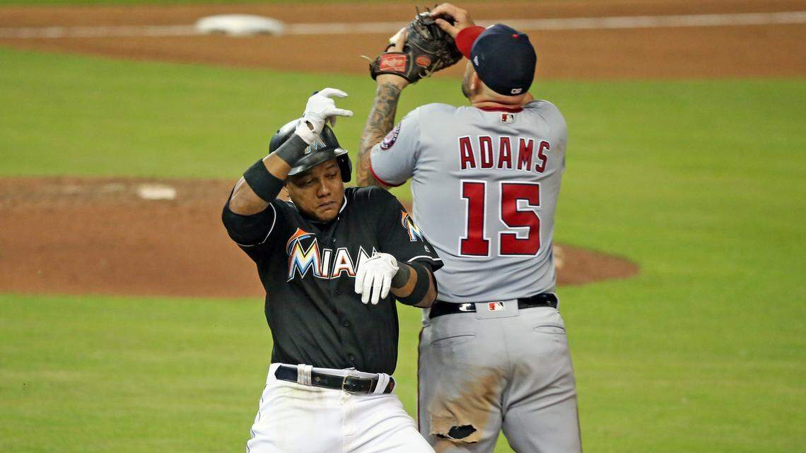 Miami Marlins second baseman Starlin Castro (13) is safe at first on throwing error by  Washington Nationals third baseman Mark Reynolds (14) in the seventh inning as the Miami Marlins host the Washington Nationals at Marlins Park on Friday, July 27, 2018.