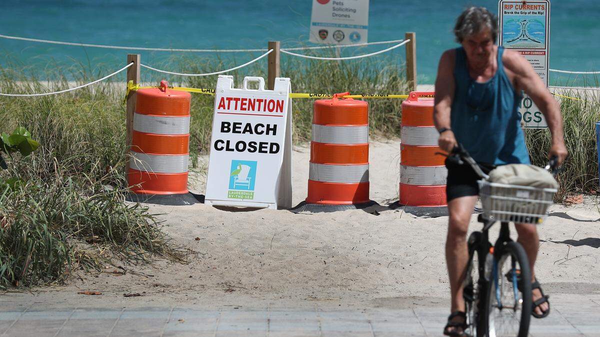 A beach closed sign in Pompano Beach on Friday, part of the state’s effort to stop the spread of the coronavirus pandemic. Being outside and exercising, like this bike rider, can help lessen anxiety.
