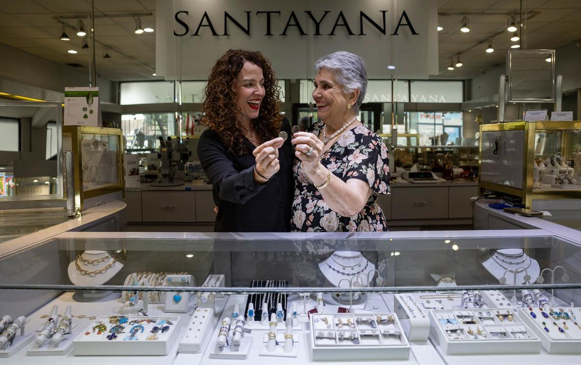 Marisa Santayana and her daughter, Elena Santayana, hold Celia Cruz-themed quarters at their store, Santayana Jewelry.
