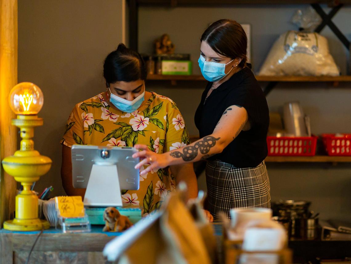 Shivani Patel, left, and manager Diana Garcia look over an order at Ghee Indian Kitchen in Dadeland. Garcia oversees the dining room being sanitized every 30 minutes.