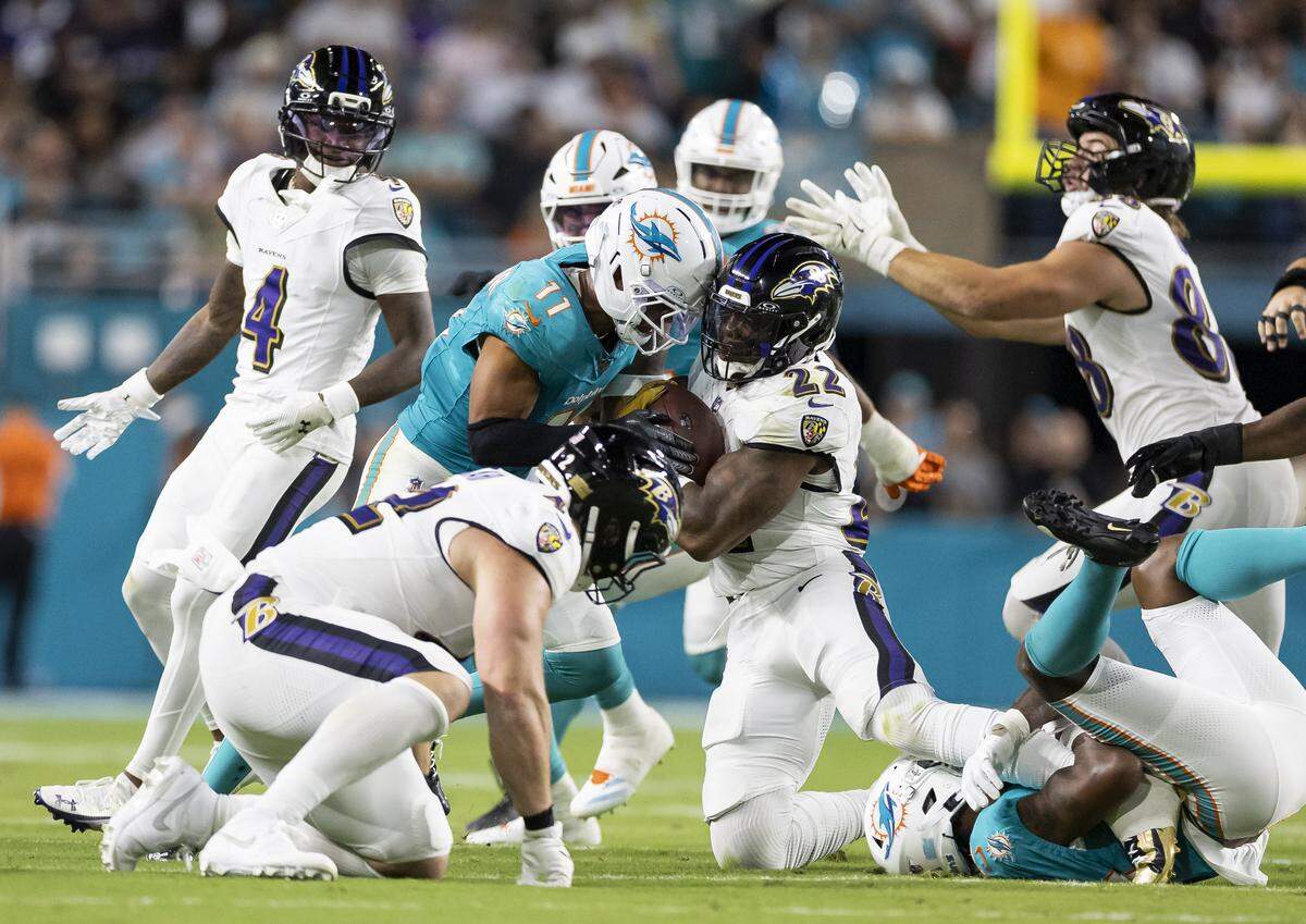 Miami Dolphins safety Dante Trader Jr. (11) tackles Baltimore Ravens running back Derrick Henry (22) in the first half of an NFL game at Hard Rock Stadium on Thursday, Oct. 30, 2025, in Miami Gardens, Fla.