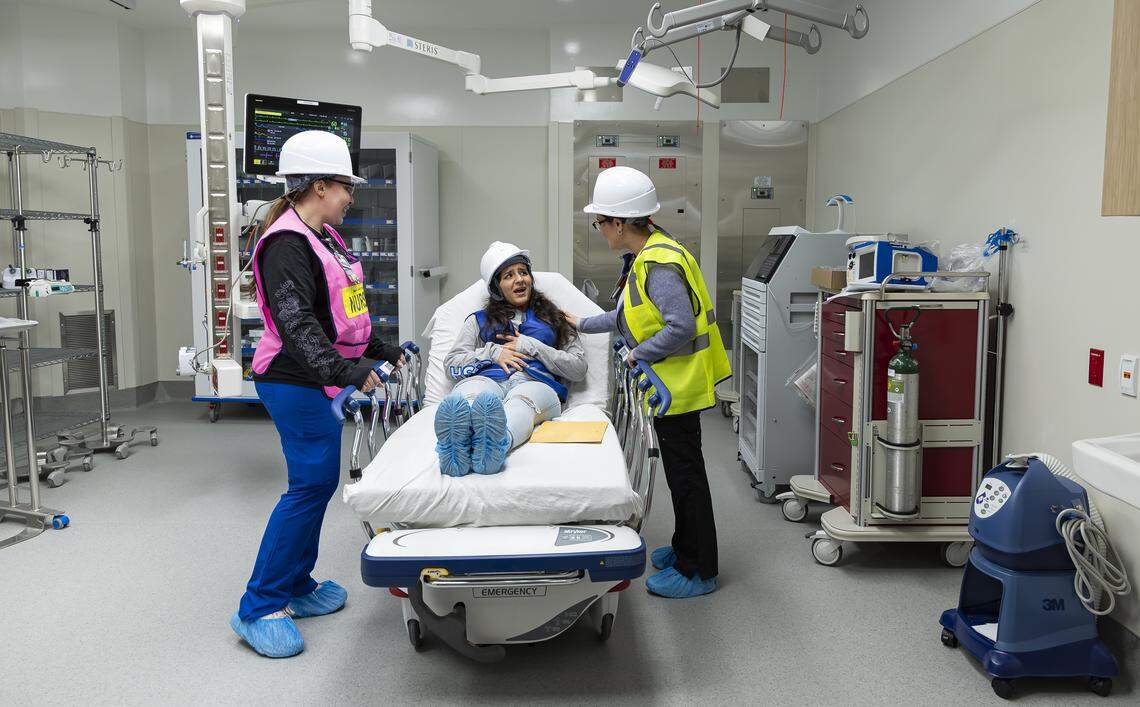 From left to right: Jackson Memorial Hospital registered nurse Anicia Dominguez, Miami Dade College student Ashley Rivera and Jackson Memorial Hospital nurse practitioner Arliette Vita perform a simulation of a patient's experience in a resuscitation area during a tour of the hospital's new emergency department on Thursday, March 5, 2026, in Miami, Fla. The new facility doubles the size of the current emergency room and is expected to reduce patient wait times.