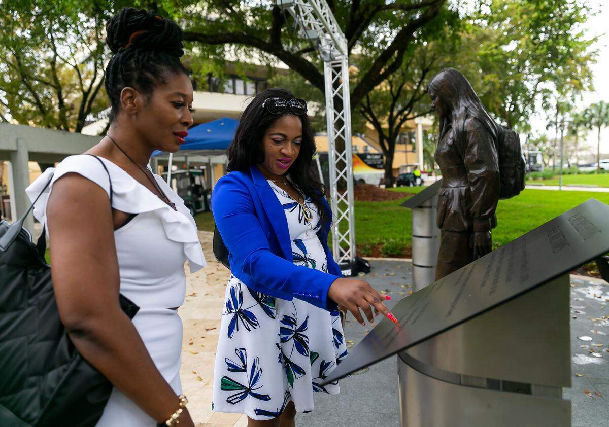Winsome Brown, the wife of Navaro Brown, center, and Marvaline Wong, visit the Alexa M. Duran Memorial at Florida International University in Miami, Florida, on Tuesday, March 15, 2022, the fourth anniversary of the FIU bridge collapse. Navaro Brown was one of the six people killed when a pedestrian bridge, still underway, collapsed on March 15, 2018.