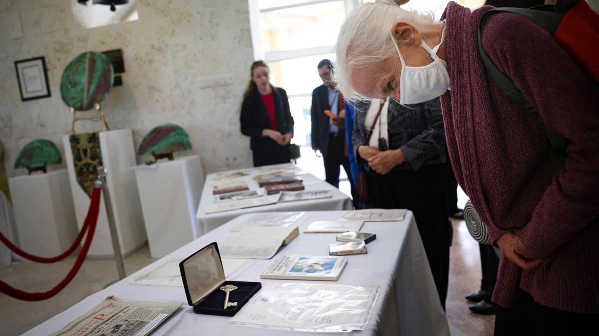 Bonnie Bolton, whose mother Roxcy was a Women’s Park founder, looks at a Key to the City of Sweetwater and other items from the time capsule during its unveiling on Wednesday, March 22, 2023, at The Women’s Park in Miami.