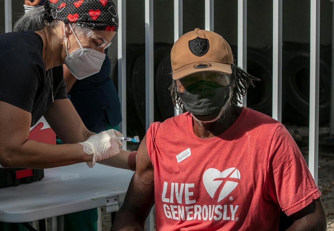 Nurse Niurka Pérez gives a shot of the (J&J/Janssen) COVID-19 vaccine to Willie Barber, a homeless man living in downtown Miami.