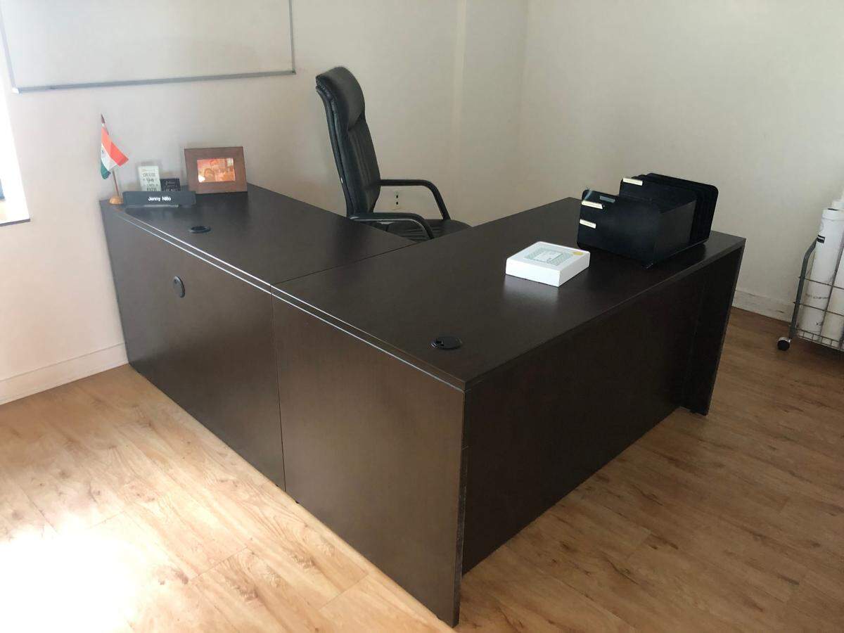 Jenny Nillo’s office at the Omni CRA building is mostly empty, including a desk with very few items on it. On the desk there’s a name plate, a few motivational quotes, a city of Miami flag, an unopened box of business cards and a framed photo of her and Alex Díaz de la Portilla.