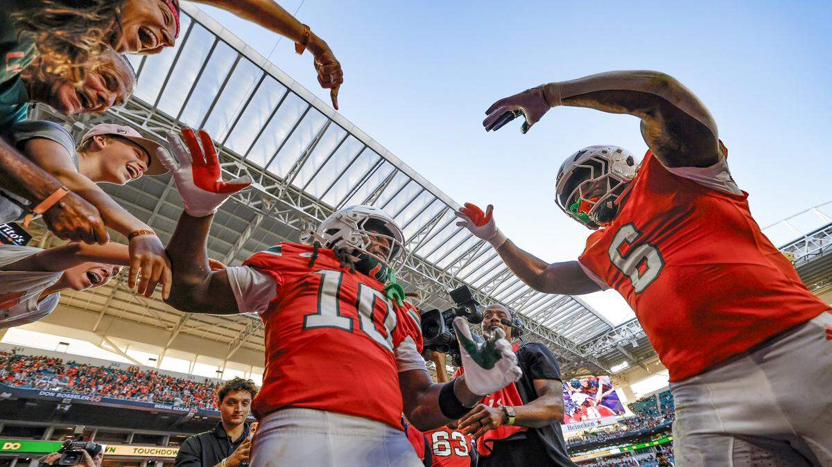 Miami Hurricanes wide receiver Malachi Toney (10) and running back Charmar Brown (6) celebrate in the endzone after Toney scores on a pass reception against the NC State Wolfpack in the first half of an NFL football game at Hard Rock Stadium in Miami Gardens, Florida, on Saturday, November 15, 2025. 