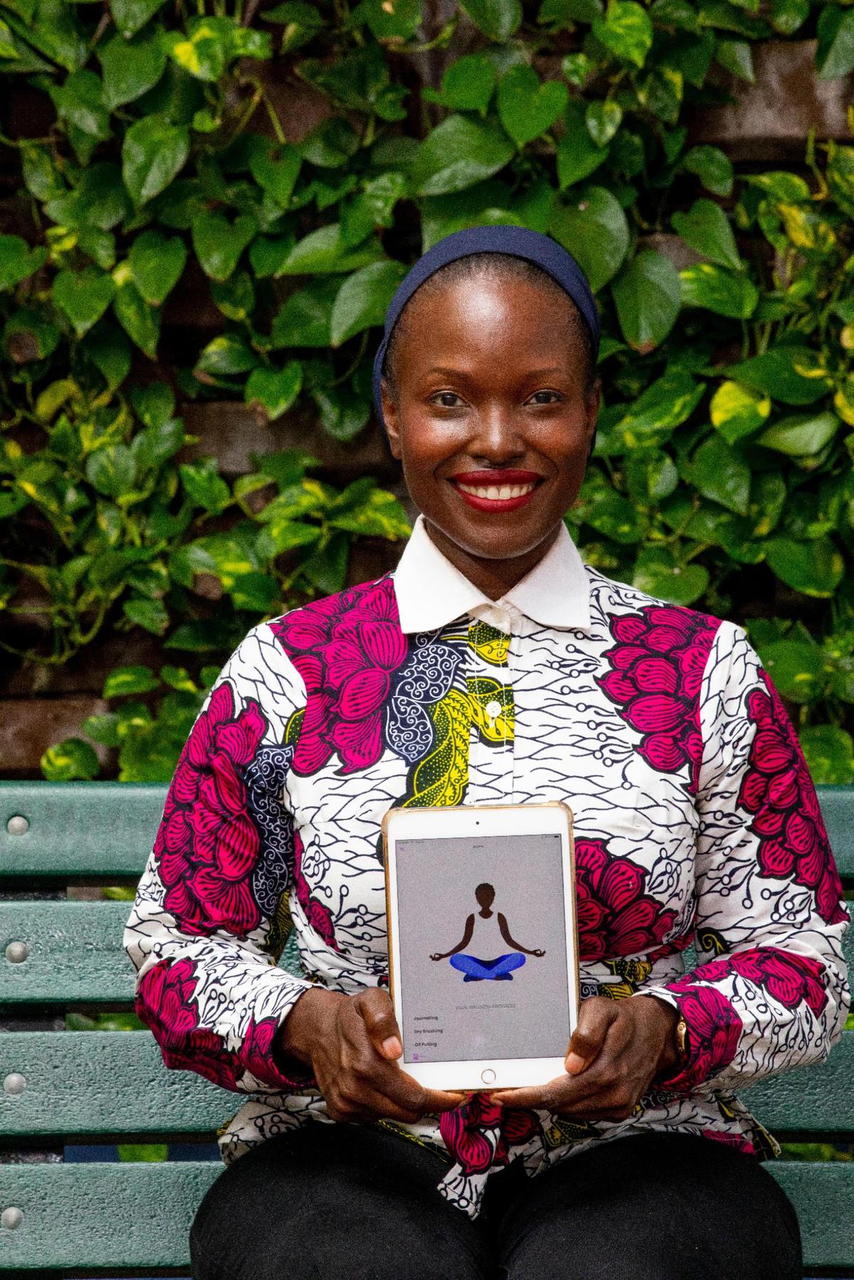 Entrepreneur Nzingah Oniwosan shows off her self-care application, 365Zing, which helps users become healthier through meal plans, yoga classes and therapy, at the Little Haiti Cultural Center in the Little Haiti neighborhood of Miami, Florida, on Friday, August 13, 2021. Oniwosan was one of thousands of Black Americans who started new businesses in 2020, a year that saw more Black entrepreneurial growth than at any time in the last 25 years, according to the Kauffman Foundation’s annual report.