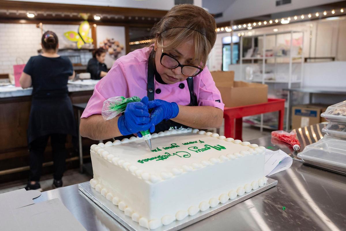 Patricia Escapa, 46, decorates a cake at the newest Misha’s Cupcakes in Coral Gables.