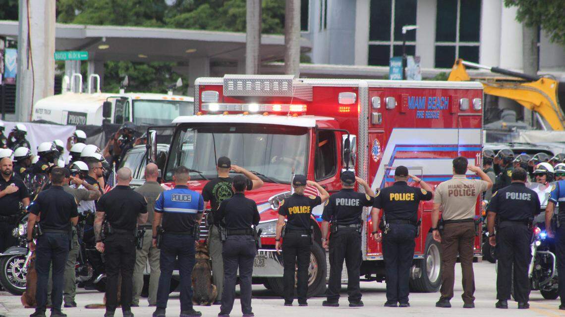 Police from South Florida law-enforcement agencies salute an ambulance carrying the body of Miami Beach Police Officer David Cajuso in front of Ryder Trauma Center at Jackson Memorial Hospital, Tuesday, Oct. 28, 2025. Cajuso died from injuries he sustained in a motorcycle crash on I-75 earlier in the day.