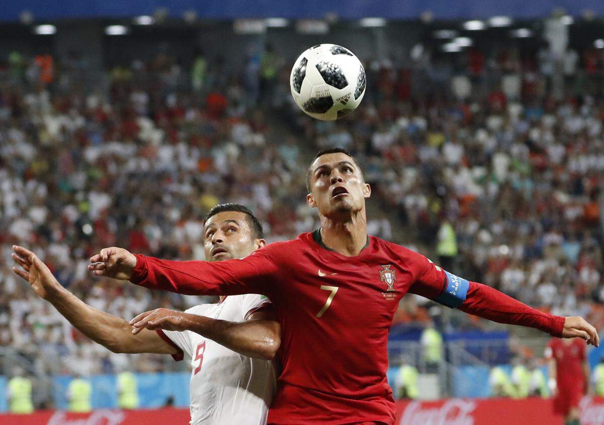 Portugal's Cristiano Ronaldo, right, and Iran's Omid Ebrahimi challenge for the ball during the group B match between Iran and Portugal at the 2018 soccer World Cup at the Mordovia Arena in Saransk, Russia, Monday, June 25, 2018.