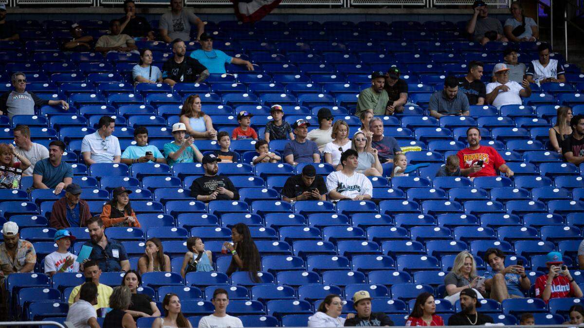 Fans watch in a relatively empty section behind the Marlins dugout during the first inning of a baseball game on Tuesday, April 2, 2024, at LoanDepot Park in Miami.