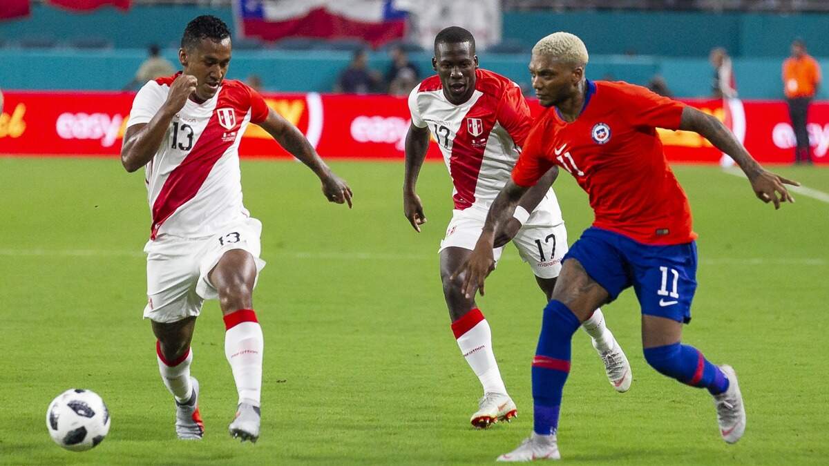 El mediocentro de Perú Renato Tapia (13) conduce el balón ante el delantero de Chile Junior Fernándes (11) en el amistoso de este 12 de octubre en el Hard Rock Stadium, en Miami Gardens.