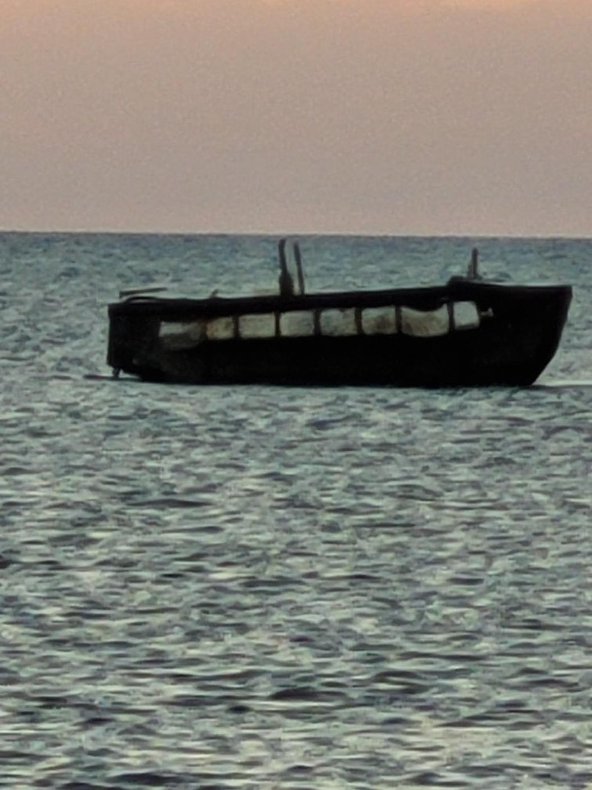 A migrant boat floats off the coast of Big Pine Key in the Lower Florida Keys on Wednesday, Jan. 18, 2023. The Border Patrol said 15 people from Cuba came to shore on the vessel. The landing came four days after people on a similar boat were rescued at sea by the crew of a passing cruise ship.