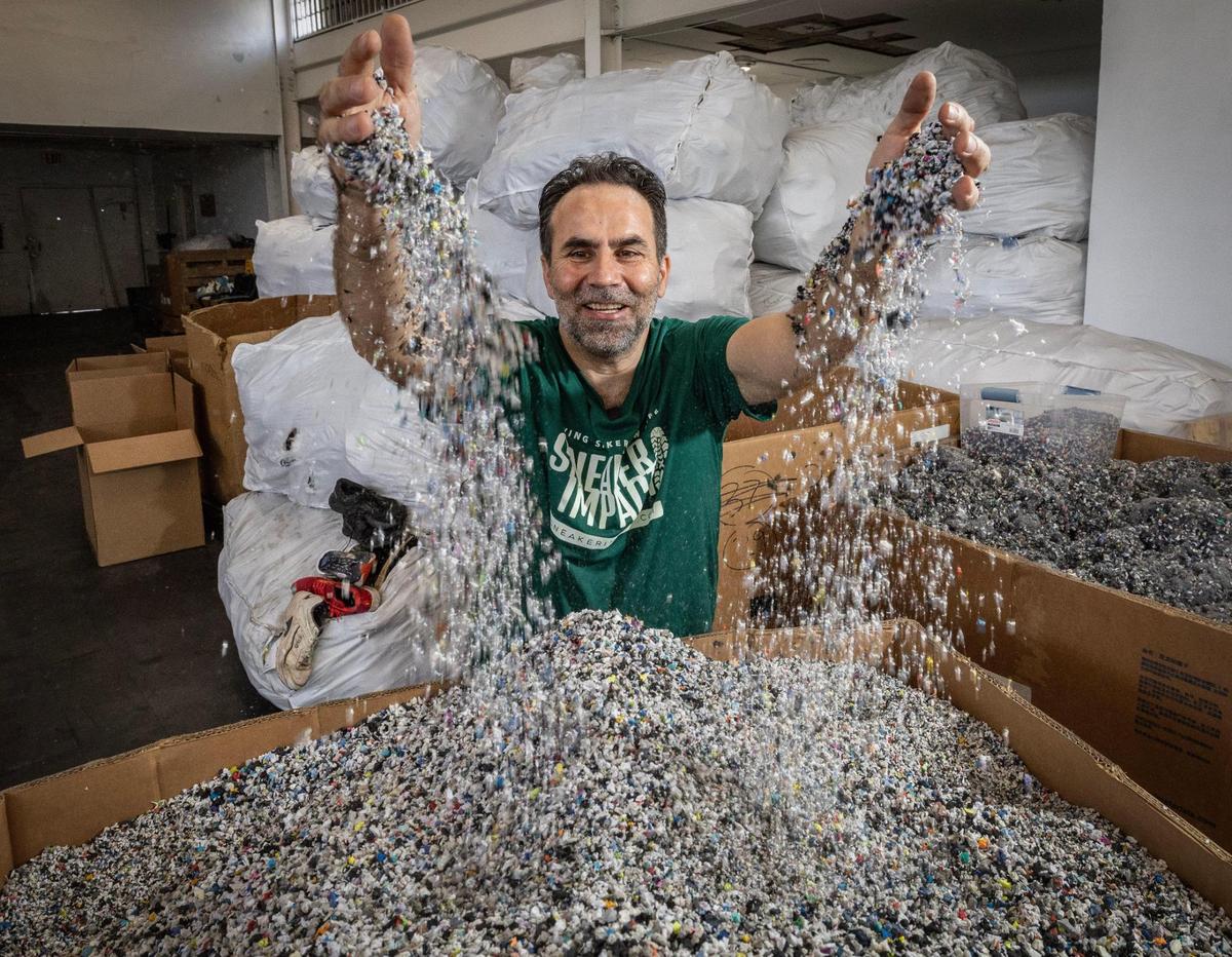 Moe Hachem, CEO and Founder of Sneaker Impact, picks up small pieces of rubber that were ground down from donated shoes at a recycling center in Little Haiti on Wednesday, April 2, 2025.