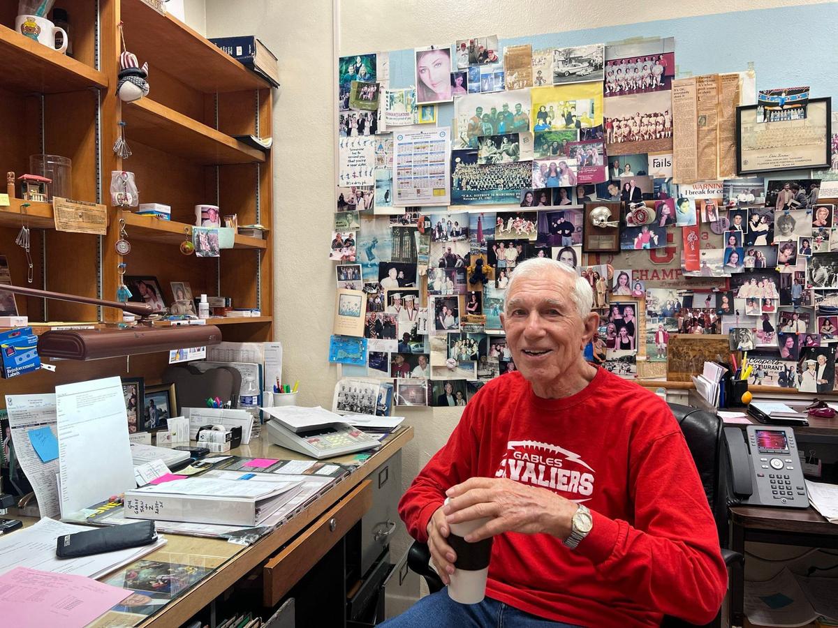 Coral Gables High School’s Daniel Finora, 90, sits in his office as he celebrates his retirement after 65 years of service.