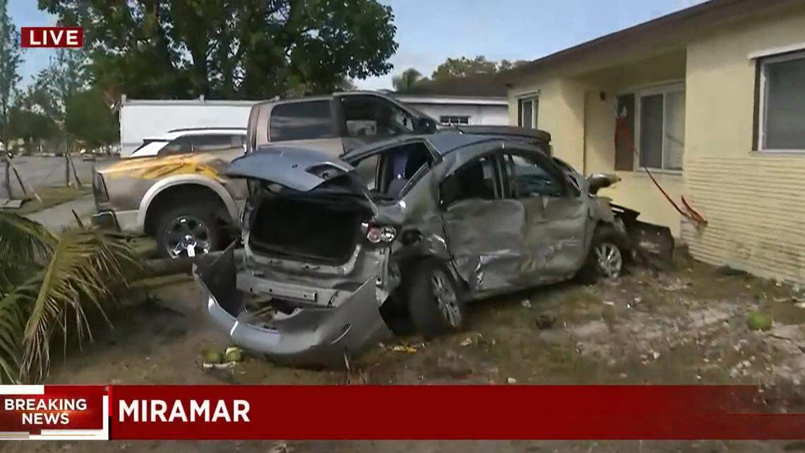 Screen grab from a WPLG Local 10 broadcast showing damaged park cars and a home in the 6500 block of Miramar Parkway after a speeding Tesla crashed here on April 10, 2021.