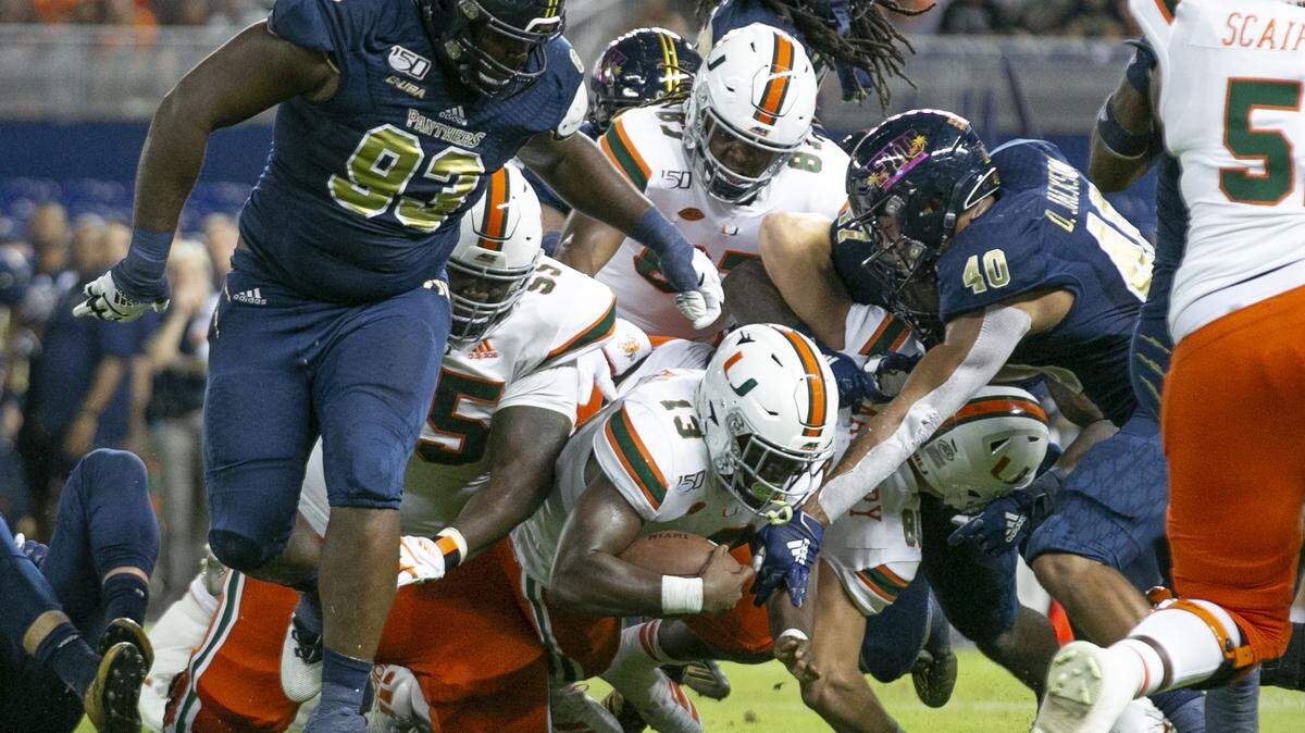 FIU stops Miami Hurricanes running back DeeJay Dallas (13) short of the goal line in the second quarter as the Florida International University Panthers host the University of Miami Hurricanes at Marlins Park in Miami on Saturday, November 23, 2019.