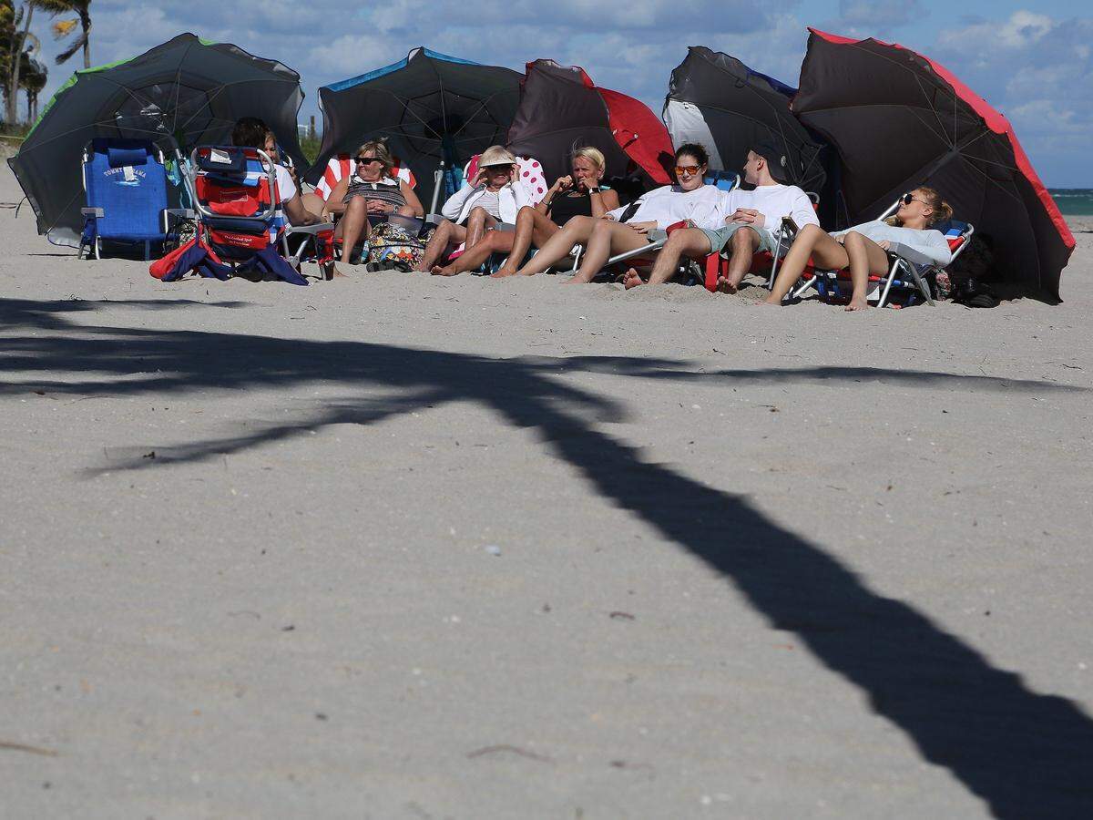Canadian snowbirds bathe in the sunlight at the beach in Hollywood, Florida.