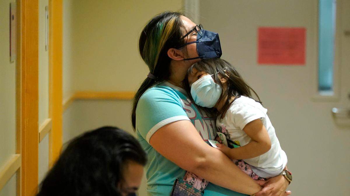 Deni Valenzuela, 2, is held by her mother, Xihuitl Mendoza, in a waiting area after Deni was given a Pfizer COVID-19 vaccine shot on Tuesday, June 21, at a University of Washington Medical Center clinic in Seattle.