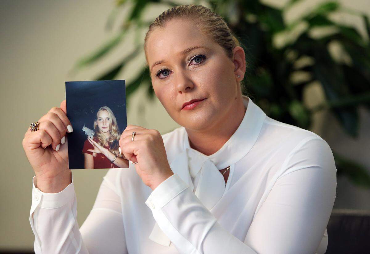 Virginia Roberts holds a photo of herself at age 16, when she alleges she was being sexually abused by Palm Beach multimillionaire Jeffrey Epstein. Roberts was employed by Epstein for massages and sex at his Palm Beach and New York homes, and traveled with him on his corporate jet to his private island, where he allegedly had her engage in sex with his friends and associates.