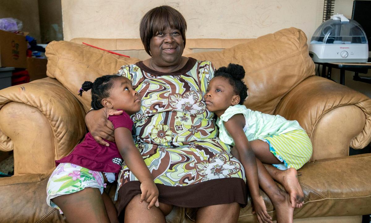 Joan Pratt sits with her grandchildren Abigail, 3, left, and Terylin, 5, right, in their Liberty City home.