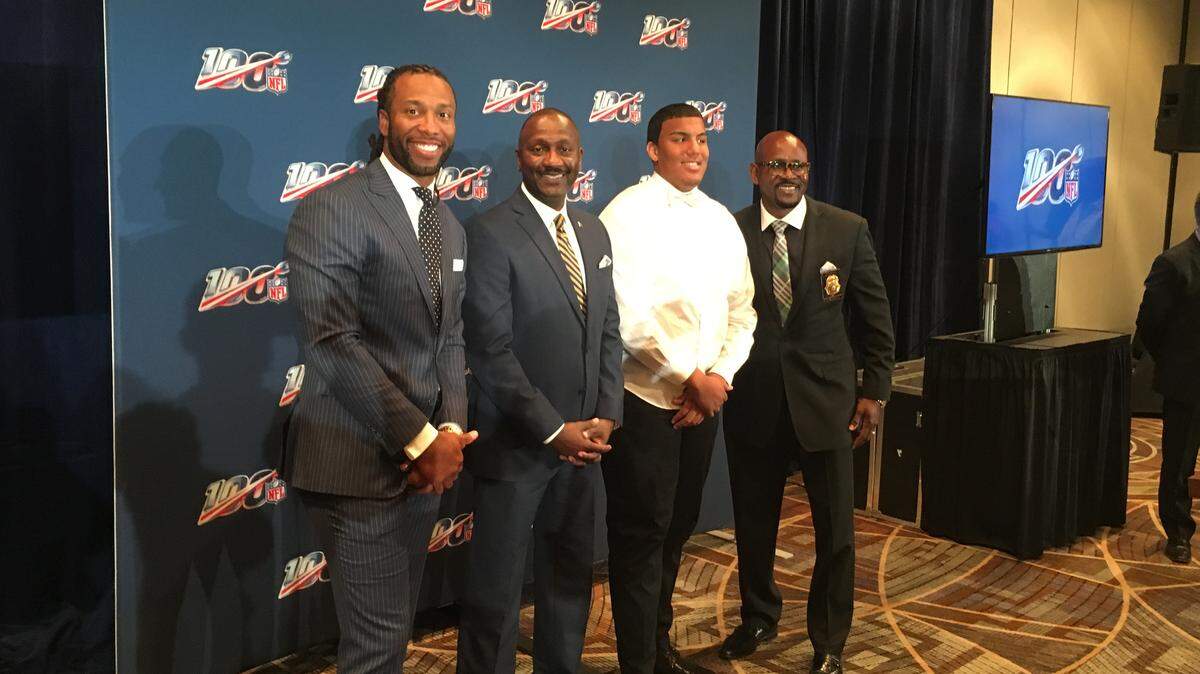 Miami Beach Detective Chris Mitchell, right, and Tyrese Cullet, standing to Mitchell’s left, pose for a picture with Cardinals receiver Larry Fitzgerald, left, and Gale Nelson, President and CEO, Big Brothers Big Sisters of Miami, at the NFL annual meeting Monday.
