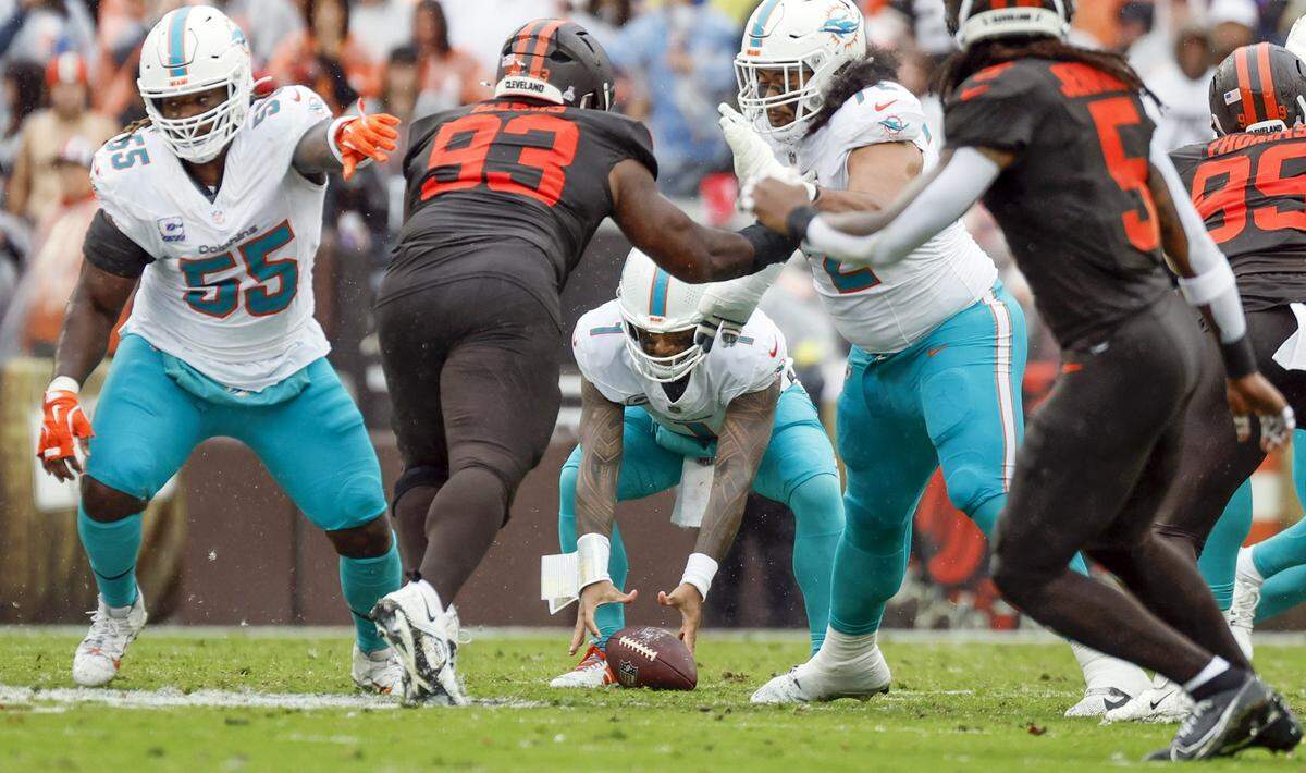Miami Dolphins quarterback Tua Tagovailoa (1) drops the snap during the first half against the Cleveland Browns of an NFL football game at Huntington Bank Field in Cleveland, Ohio, on Sunday, October 19, 2025.