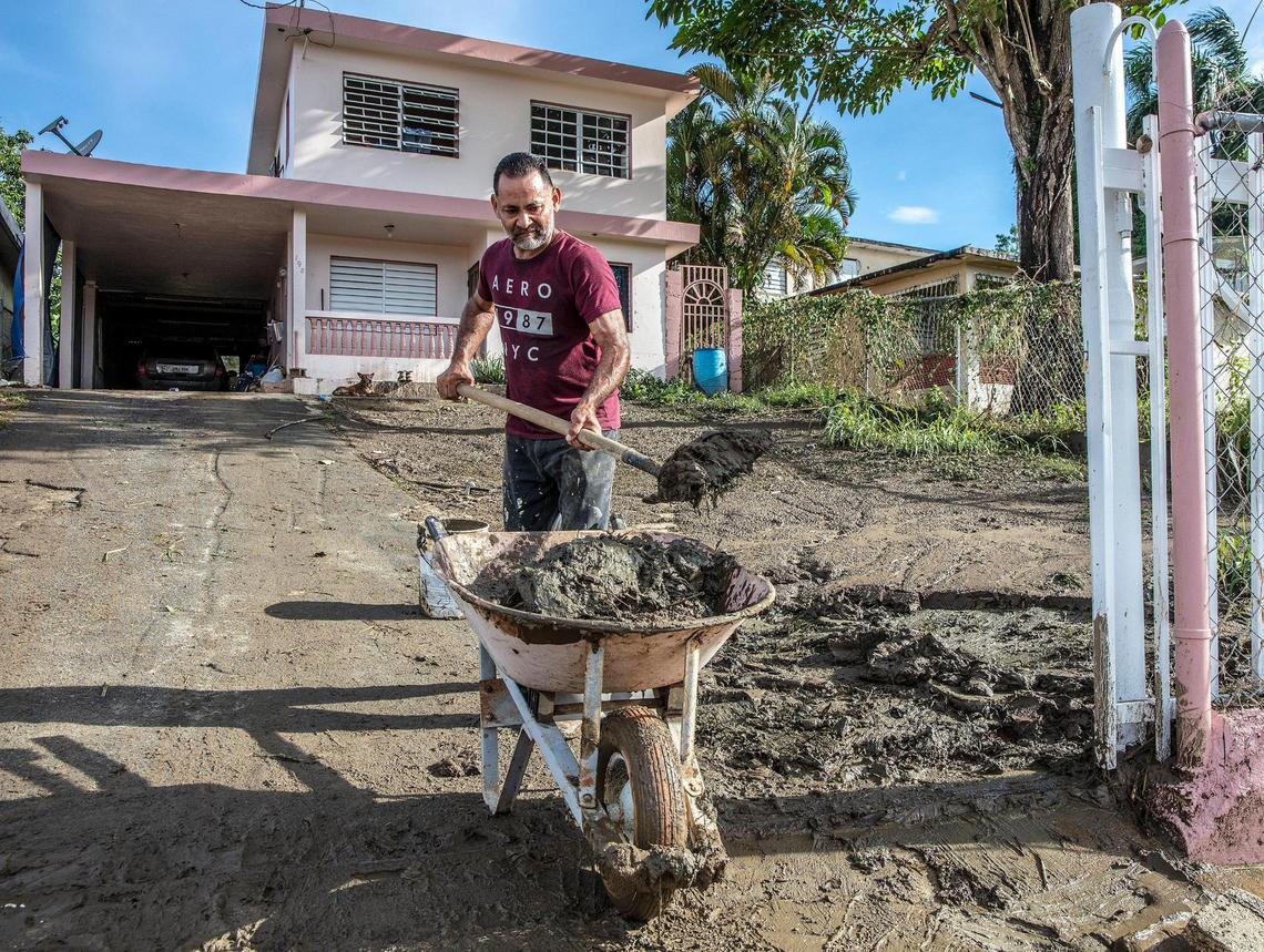 Samuel Santiago removes mud from the front of his house in the San Jose de Toa Baja neighborhood on Tuesday, Sept. 20, 2022.