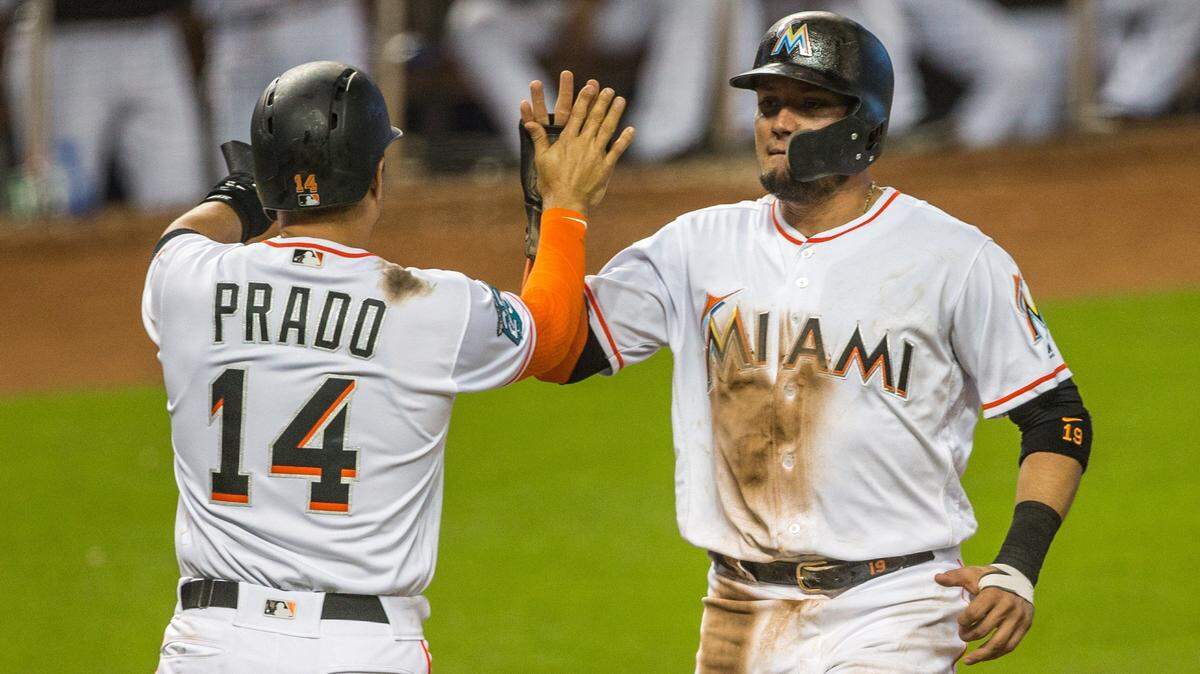 Miami Marlins Martin Prado (14) celebrates with Miami Marlins Miguel Rojas (19) after a two RBI single by Miami Marlins first baseman Justin Bour (41) during the fifth inning to extend the lead over Philadelphia to 8-5 at Marlins Park in Miami, Sunday, July 15, 2018.
