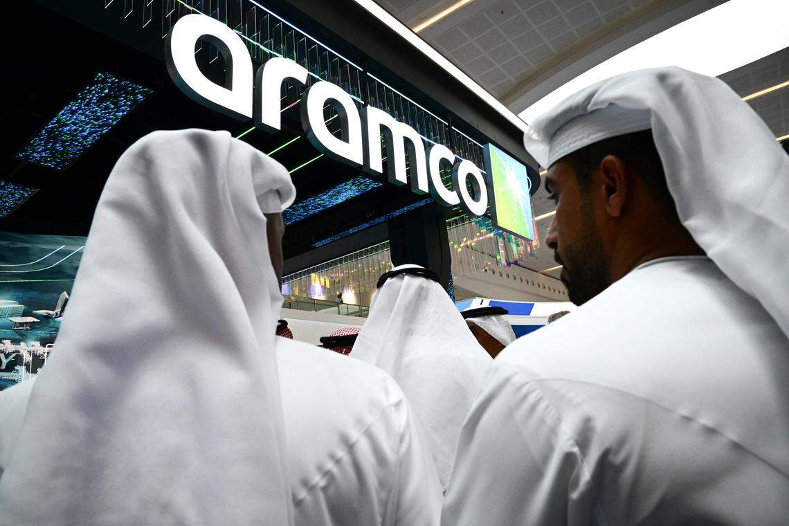 Guests stand at the booth of the ARAMCO (officially the Saudi Arabian Oil Company), during the Abu Dhabi International Petroleum Exhibition & Conference (ADIPEC) in Abu Dhabi on November 3, 2025. (Photo by GIUSEPPE CACACE/AFP via Getty Images)