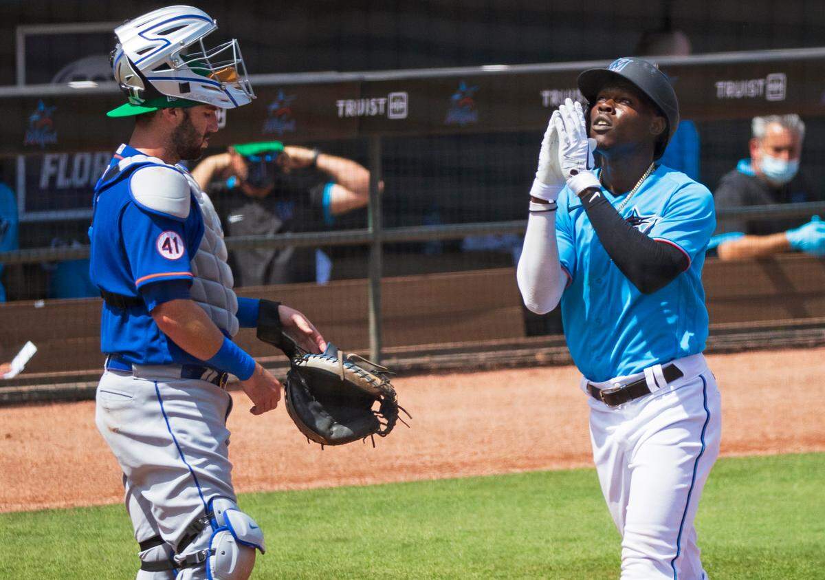 New York Mets catcher Tomas Nido (3) looks on as Miami Marlins second baseman Jazz Chisholm (2) scores after hitting a solo home run during the fifth inning of their spring training baseball game at Roger Dean Chevrolet Stadium on Wednesday, March 17, 2021 in Jupiter, Florida.