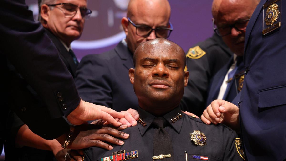 Wayne Jones, center, a 27-year veteran of the Miami Beach Police Department, closes his eyes while chaplains place their hands on him during the Benediction after being sworn in as Miami Beach’s first Black police chief in the city’s 108-year history at the New World Center in Miami Beach, Florida, on Thursday, August 31, 2023.