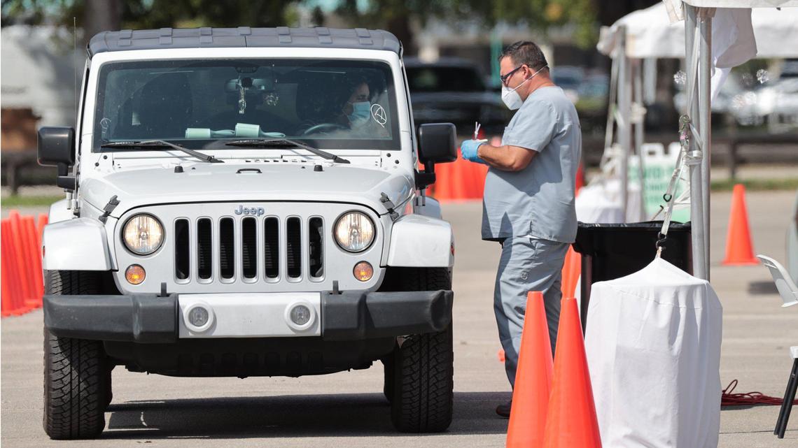 In early October 2021, a motorist prepares to be vaccinated at the Miami-Dade County COVID-19 Community-Based Testing & Vaccination Site at Tropical Park.