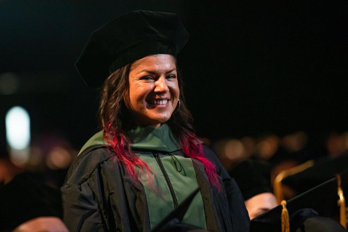 Aisha Visram stands as her name is called during Florida International University’s commencement ceremonies at the Ocean Bank Convocation Center at the Modesto A. Maidique Campus in Miami on Tuesday, Dec. 13, 2022.