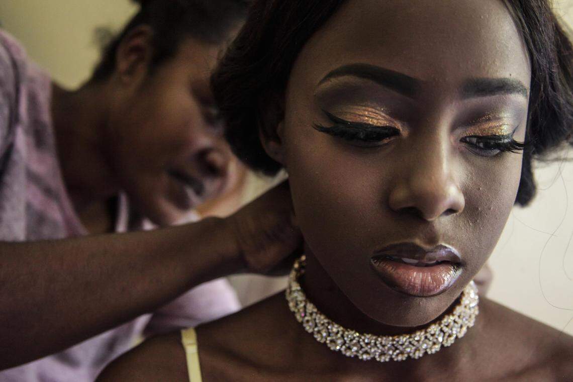 Sherley Limage, mother of Claudia Medeus, helps her daughter with a necklace for prom on Saturday, May 18, 2019, in Coral Springs. Claudia, a senior at Coral Glades High in Coral Springs, was diagnosed with rhabdomyosarcoma, the most common soft tissue cancer in children and adolescents.