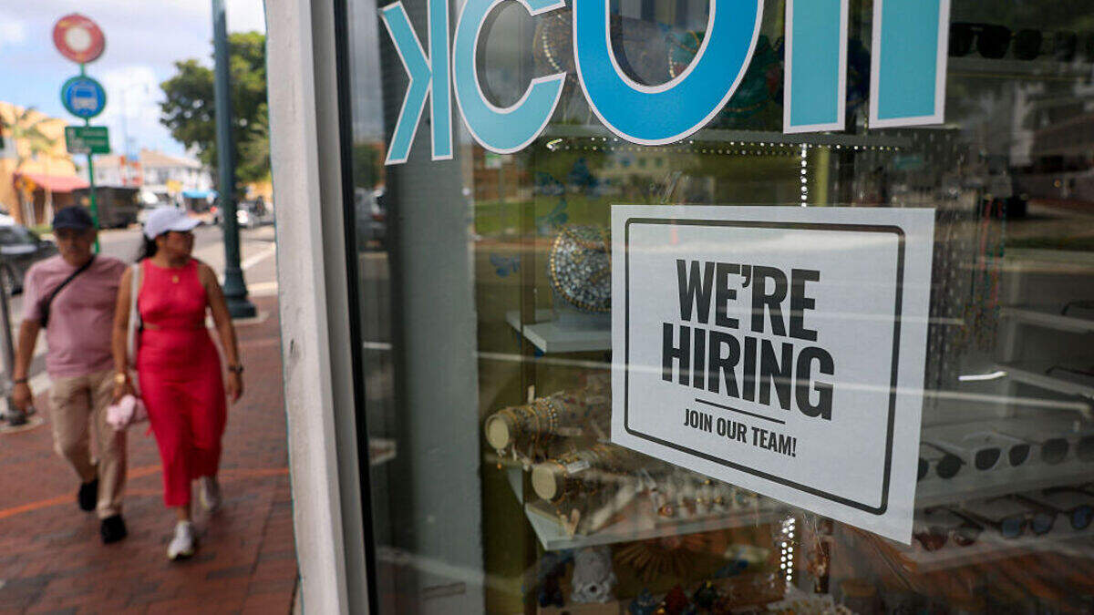 A “We're Hiring” sign is taped to the window of a business on Oct. 3, 2025, in Miami.