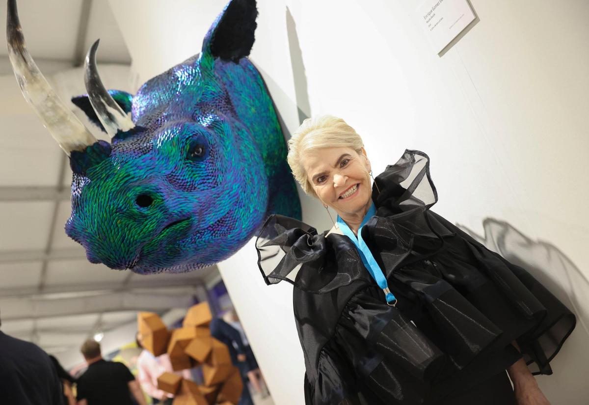 Bernice Steinbaum, curator of the Bernice Steinbaum Gallery, poses with artwork during the opening night of VIP for Art Miami on Tuesday, Nov. 29, 2022, at CONTEXT Art Miami.