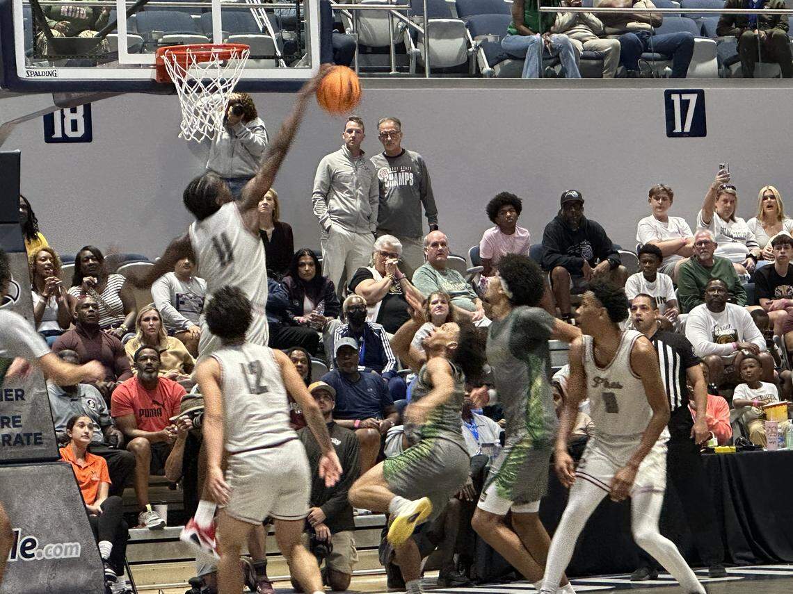 Pembroke Pines Charter’s Robert Guishard (11) blocks a Fleming Island shot near the rim during Friday's Class 5A boys’ basketball state championship game at UNF Arena in Jacksonville, Fla.