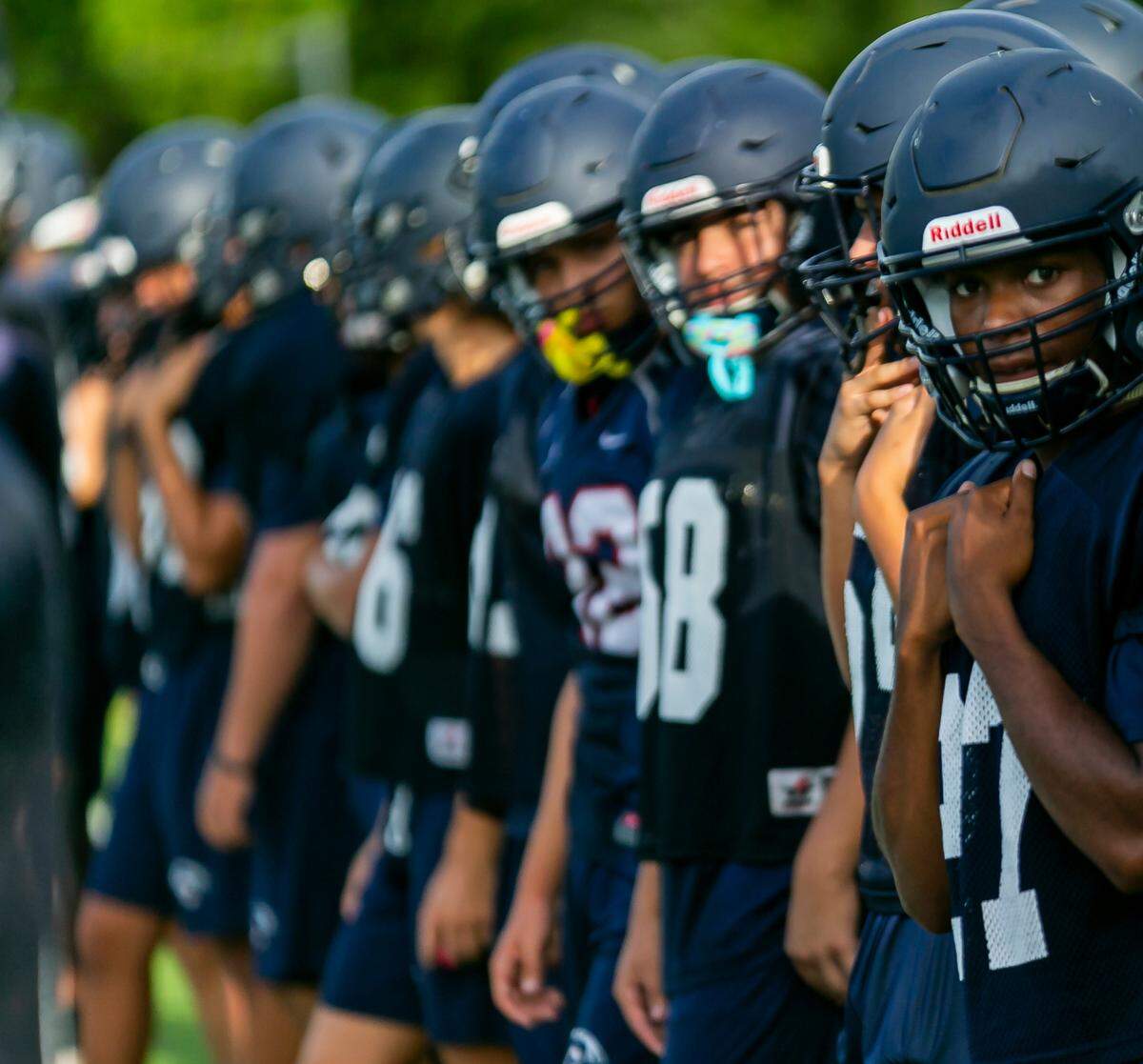 Christopher Columbus players watch as their teammates perform drills during a preseason practice at their school in Miami’s Westchester neighborhood on Wednesday, August 4, 2021.
