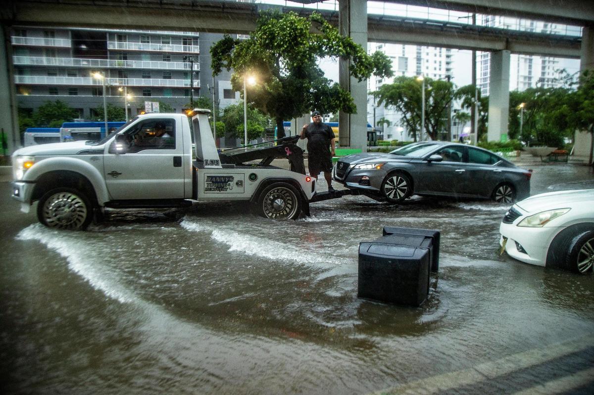 Tow trucks removed flooded cars as massive rainfall from a disturbance caused serious floods Saturday morning in the Brickell area near downtown Miami.