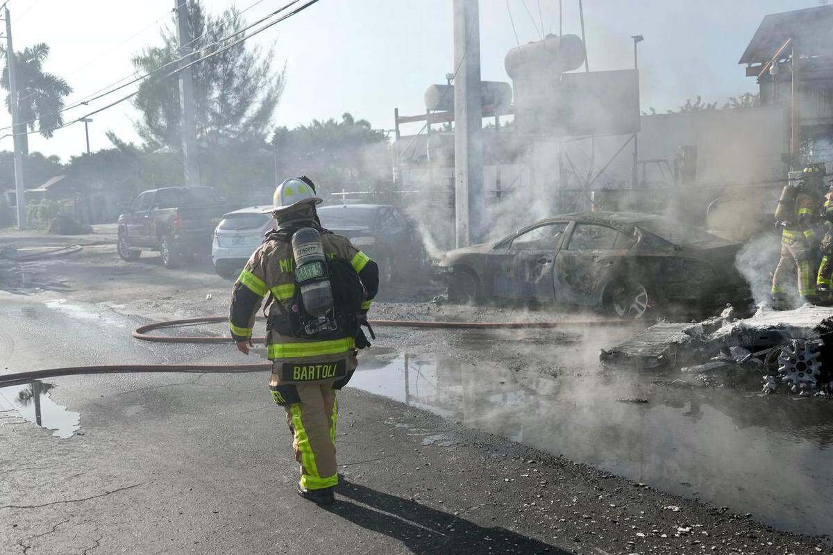 Miami-Dade firefighters working the scene where multiple vehicles were on fire at 11350 NW South River Dr. on Tuesday, February 21, 2023.