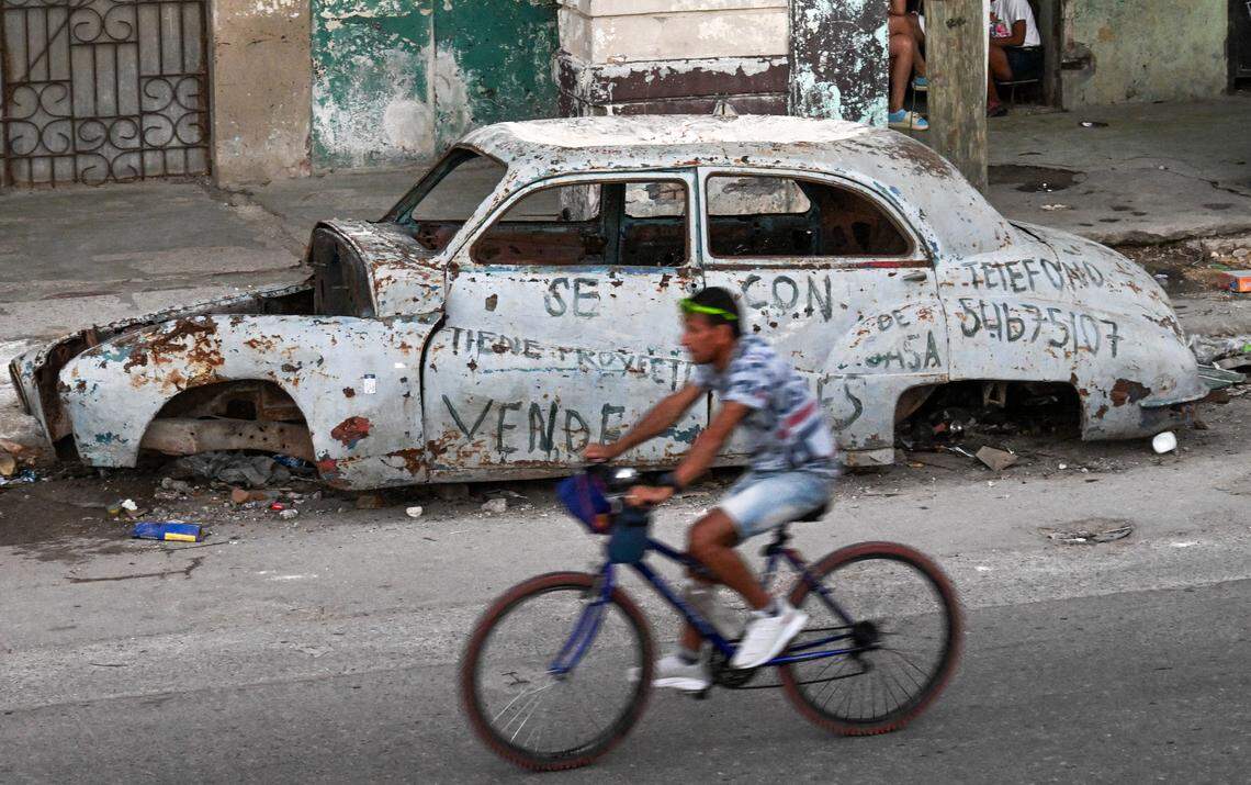 A man rides past an abandoned car in Havana on February 4, 2026.