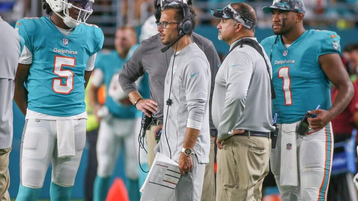 El entrenador de los Dolphins, Mike McDaniel, habla con. el quarterback Teddy Bridgewater (5) , mientras el otro QB, Tua Tagovailoa (1), observa durante el partido de pretemporada contra los Eagles, el 27 de agosto de 2022. en el Hard Rock Stadium