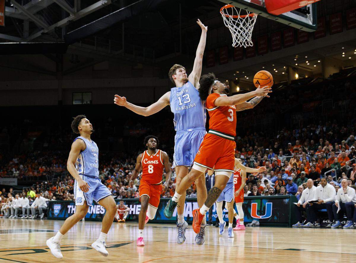 Miami Hurricanes guard Tre Donaldson (3) shoots around North Carolina Tar Heels center Henri Veesaar (13) during the first half of a game on Tuesday, Feb. 10, 2026, at the Watsco Center in Coral Gables, Fla. 