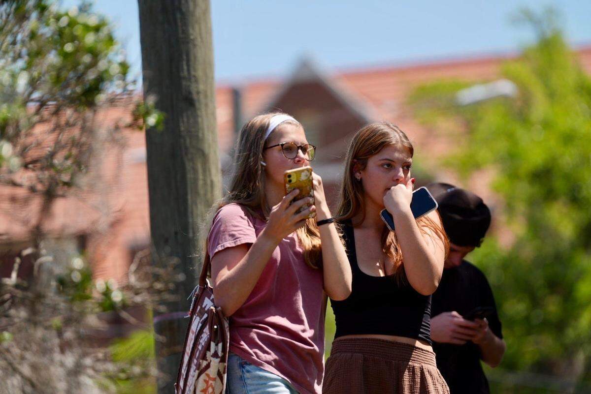 Evacuees watch law enforcement on FSU campus after a mass shooting Thursday afternoon.