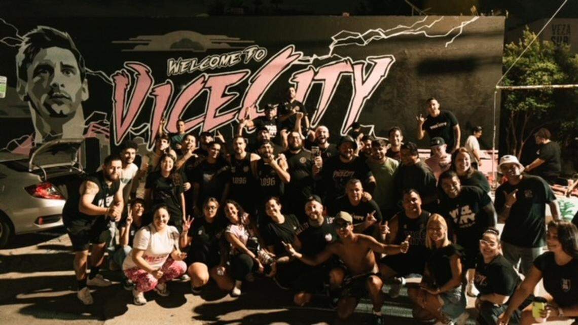 Members of Inter Miami’s Vice City 1896 supporters group pose in front of their Welcome Lionel Messi mural in Wynwood at 55 N.W. 25 St.